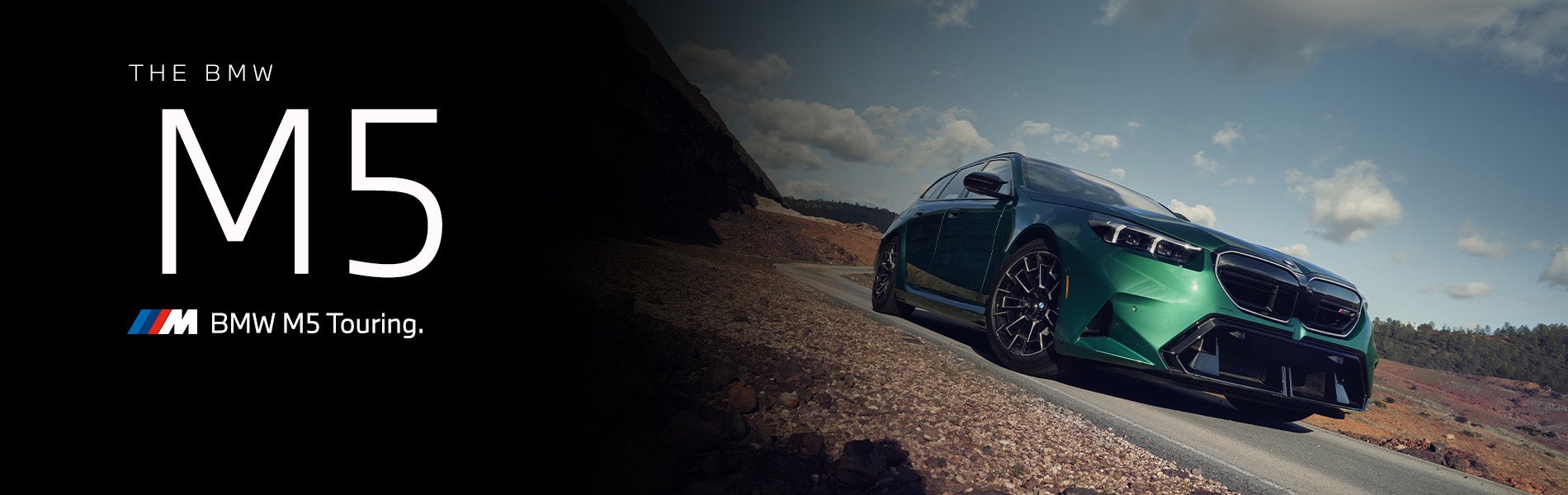 The new BMW M5 Touring in green driving down desert road | BMW of Okemos in Okemos MI