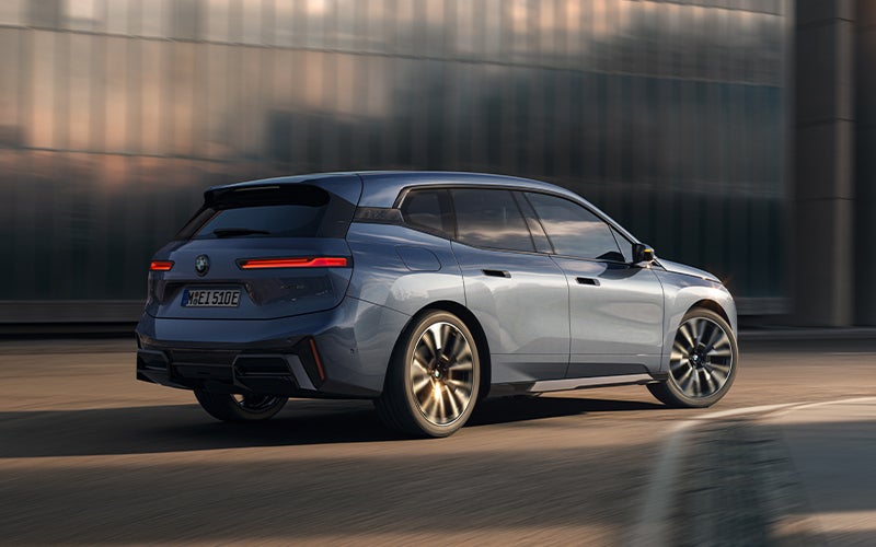 The BMW iX driving with the front wheel turned. | BMW of Okemos in Okemos MI